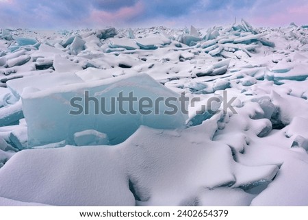 Winter landscape at dawn of blue ice shards and snow covered shoreline of Lake Michigan, Empire Beach, Sleeping Bear Dunes, Michigan, USA