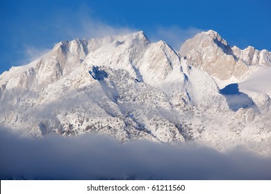 Winter Landscape Of The Eastern Sierra Nevada Mountains Covered In Snow And Framed By Fog And Clouds, Lone Pine, California, USA