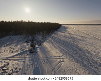 Winter landscape in Estonia, a hunting observation tower between a forest and a field, photo view from a drone.  - Powered by Shutterstock