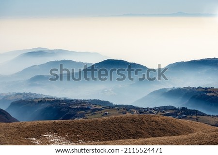 Winter landscape of the Lessinia plateau (Altopiano della Lessinia) and the Padana Plain or Po valley with fog. On horizont the mountain range of the Apennines. Erbezzo, Verona, Veneto, Italy, Europe.