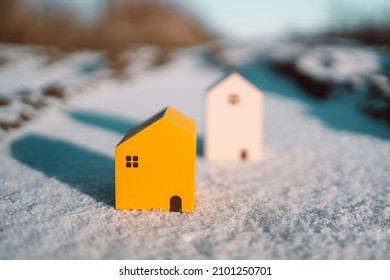 Winter Landscape With Miniature Model Of Wooden Houses With Sunlight On Winter Snow Background. Home, Loan, Money Investment Concept.