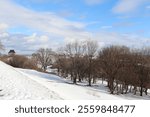 Winter landscape in a park in Quebec city with trees, landmark and a blue sky. Outdoor activities in winter and december calendar. A background with snow and an horizon. Plains Abraham in winter.