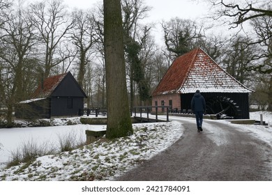 winter landscape with road with bend, with watermill and hiker - Powered by Shutterstock