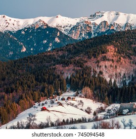 winter landscape in Romania with Haystacks, traditional village, snowy Bucegi mountains (Carpathians) in Transylvania. Romanian nature, countryside landscape, scenery in wintertime.  - Shutterstock ID 745094548