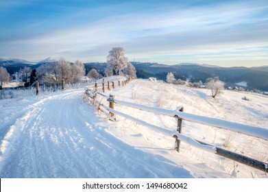 Winter Landscape. Rural Road Covered With Snow. Mountains On Horizon