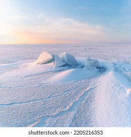 Winter Landscape. Snowdrifts On The Ice Surface During Sunset.