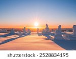 Winter landscape at sunset in Finnish Lapland. Cold winter with lot of snow and blue sky. Spruce trees covered by snow