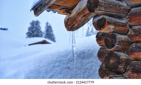 Winter Landscape In Swiss Alps With Icicle On Chalet Roof