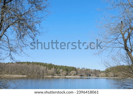 Winter landscape, white shore of a lake or river with snow and ice