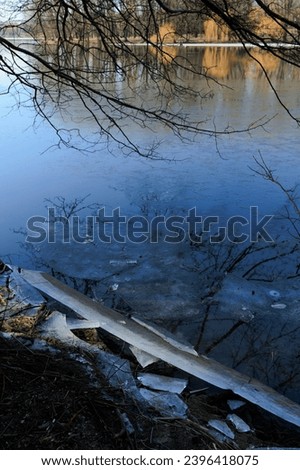 Winter landscape, white shore of a lake or river with snow and ice