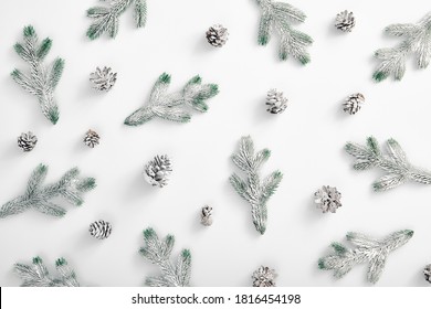 Winter minimal concept - Evergreen tree branch with snow and pine cones. Horizontal composition, flat lay, top view. Snow forest creative minimal layout. Snowy pattern template