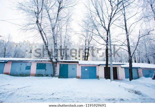 Winter\
morning. Chain of garages surrounded by snow\
piles
