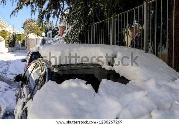 Winter morning snow\
covered car on the street of Athens, Greece, 8th of January 2019.\
Horizontal. Close-up.