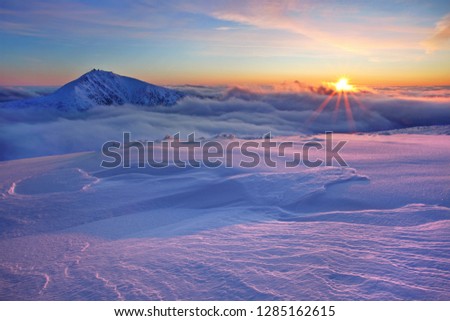 Winter mountain landscape with fog in the Giant Mountains on the Polish and Czech border - Karkonosze National Park.
Scenic view of sun shining over snow covered Giant mountains