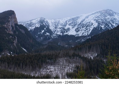 Winter mountain landscape with the image of the Tatra Mountains on the border of Poland and Slovakia - Kasprowy Wierch mountain road with snow lying on a slope. Zakopane, Poland.