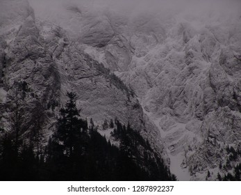 Winter mountain wiev, close up for black and white rocky wall covered by snow