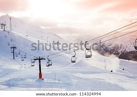 Winter mountains panorama with ski slopes and ski lifts on a cloudy day