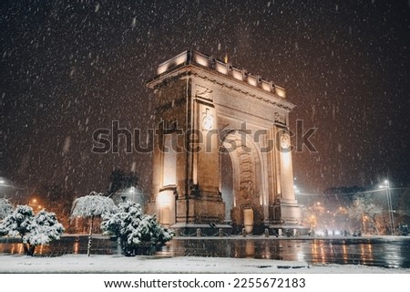 Winter night in Bucharest. Arch of Triumph landmark building under snowfall during a winter evening in Bucharest, Romania.