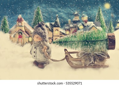 winter night scene with a boy pulling a sled with christmas tree