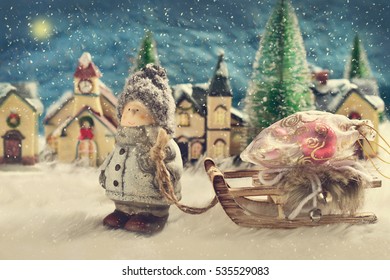 winter night scene with a boy pulling a sled with christmas gifts