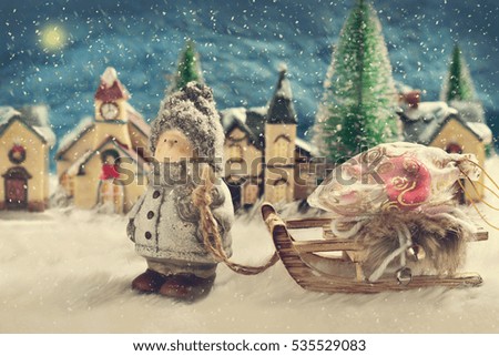 winter night scene with a boy pulling a sled with christmas gifts