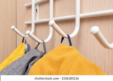 Winter outerwear, coat hanging on a hook of a coat rack in hallway, anteroom at home - Powered by Shutterstock