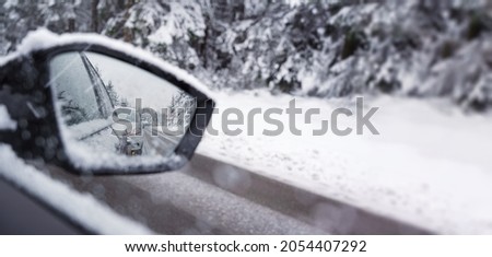 winter panorama on the road in the rearview mirror of a car