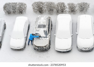 Winter parking lot cars under snow covered cars snow clearing. Parked cars snow removal. Cover winter yard above view top. Courtyard. Winter season. Cold weather conditions. Snowbound. Frosty morning