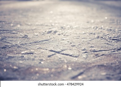 Winter Pattern From Figure Skates On Shining Ice Skating Rink With Snowflakes As Christmas Background