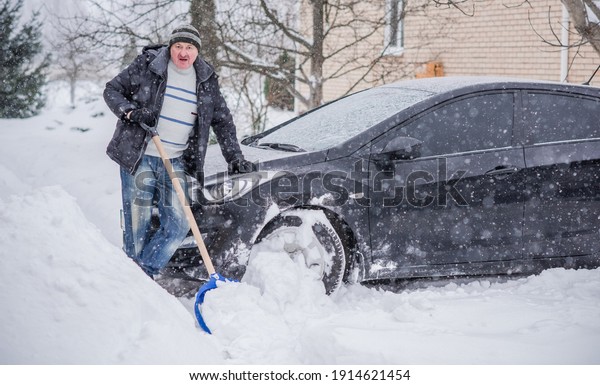 Winter, people and car problem concept. Man try on
pushing the car, stuck in the snow. Mutual aid. Winter problem.
transportation, winter and vehicle concept - closeup of man pushing
car stuck in snow