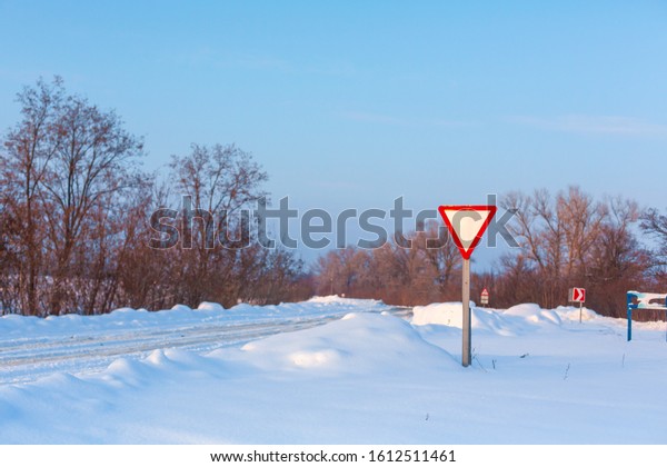 Winter poorly cleared
road. Road in the countryside strewn with snow. Winter landscape
with snowdrifts.