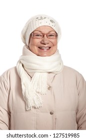 Winter portrait of smiling elderly lady, wearing warm coat, cap and scarf.