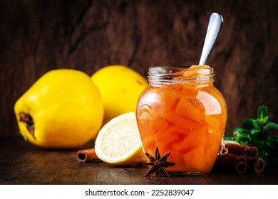 Winter Quince jam or confiture in glass jar with cinnamon and anise on rustic wooden kitchen table background, copy space - Shutterstock ID 2252839047