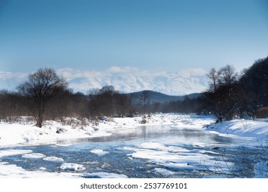 Winter riverbanks and snowy mountains with blue sky
 - Powered by Shutterstock