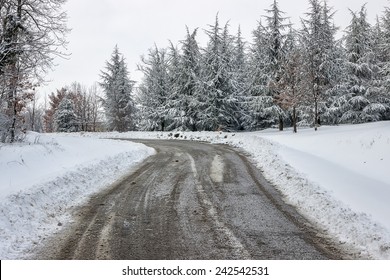 Winter Road Care, Just Spread Mixture Of Salt And Sand Over The Ice On A Snow Covered Road. Cleaning A Road In Winter, Sand And Salt On Road.