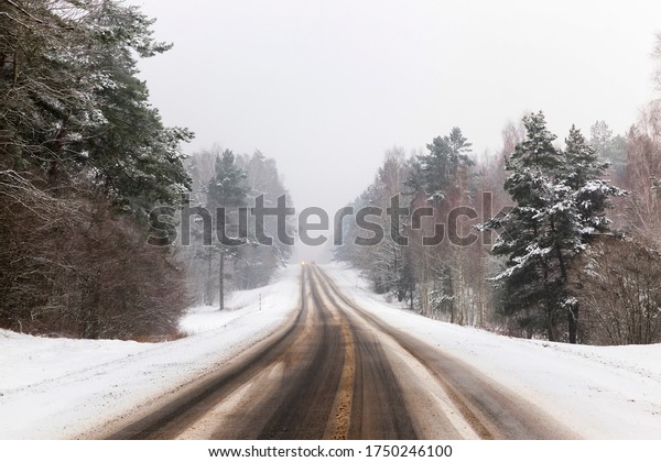 winter road for driving cars\
in the winter season, covered with snow after snowfall, tracks from\
cars