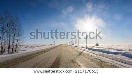 Winter road outside the city, cleared of snow in the countryside. Large snowdrifts on the side of the road.                          