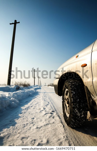 winter road perspective with an off road tire\
as foreground tour drive car white front romania snow winter travel\
season engine skyline detail abstract colored technology metal view\
model performance
