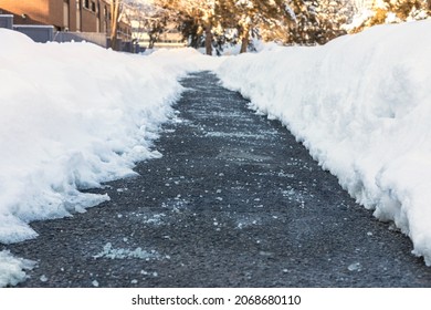 Winter road with salt for melting snow near townhouses - Shutterstock ID 2068680110