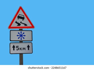 Winter road with Road sign of slippery road, direction of travel.warning sign about the snowfall on the snowy road . - Shutterstock ID 2248651167