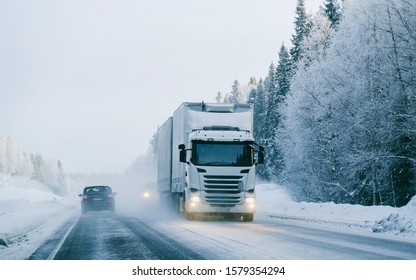 Winter Road With Snow. Truck In Finland. Lorry Car And Cold Landscape Of Lapland. Europe Forest. Finnish City Highway Ride. Roadway And Route Snowy Street Trip. Delivery In Downhill Driveway Driving