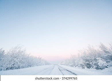 Winter road, snowy trees. Minimalistic landscape with a gradient blue sky. - Powered by Shutterstock