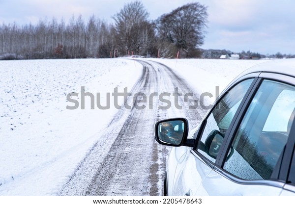 Winter road trip in Sweden by car. Car winter\
driving vacation in the Swedish or Scandinavian cold lands. Nordic\
driving holiday on a frozen trail or path in the freezing\
countryside in Skane\
county