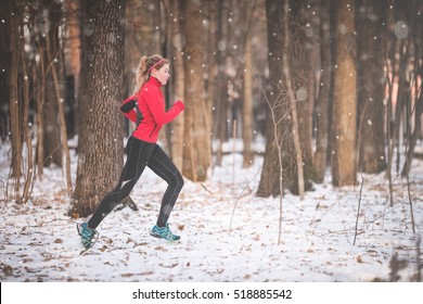 Winter Running Exercise. Runner Jogging In Snow. Young Woman Fitness Model Running In A City Park 