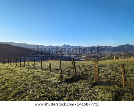 Winter rural landscape: Wooden fence surrounded by frozen pastures on a cold winter day
