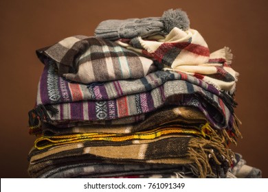 winter scarfs with blankets and hat isolated on brown