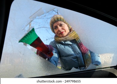 Winter Scene, Adult Woman Scraping Ice From Windshield Of Car