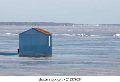 Winter Scene: Blue Ice Fishing House On Frozen Lake