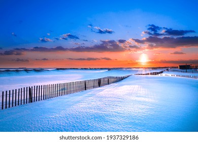 Winter Scene Under Color Sky At Sunset On Snow Covered Beach. Jones Beach State Park., Long Island NY