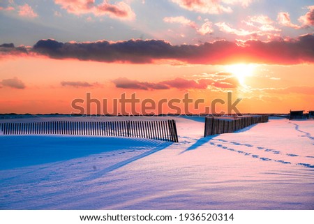 Winter scene under color sky at sunset on snow covered beach. Jones Beach State Park., Long Island NY